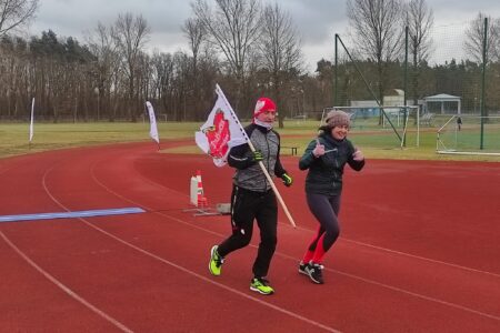 zawodnicy podczas biegu z flagą WOŚP